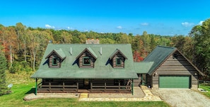 A log cabin with a green roof, multiple windows, and a garage. - Wow! Timber Ranch Lodge, 43 acres, Sleeps 12, Family and Pet Friendly!  (Logan)