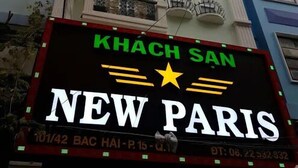A building with a sign for "KHACH SAN NEW PARIS" and a contact number. - New Paris Hotel - by Bay Luxury (Ho Chi Minh City)