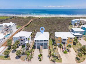 A coastal residential area with beachfront properties, a wooden boardwalk, and a clear view of the ocean. - Shared Pool, Pet Friendly, Gulf Views and Golf Cart Included (Port Aransas)