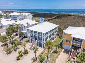A coastal hotel with multiple buildings, a boardwalk, and a view of the ocean.