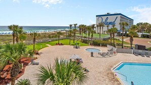 A hotel with a large pool, a beach view, and a sign reading "Orlando".