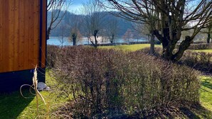 A wooden cabin with a view of a lake and mountains in the background. - Tiny Haus Waldsee Lodge by Interhome (Wemding)