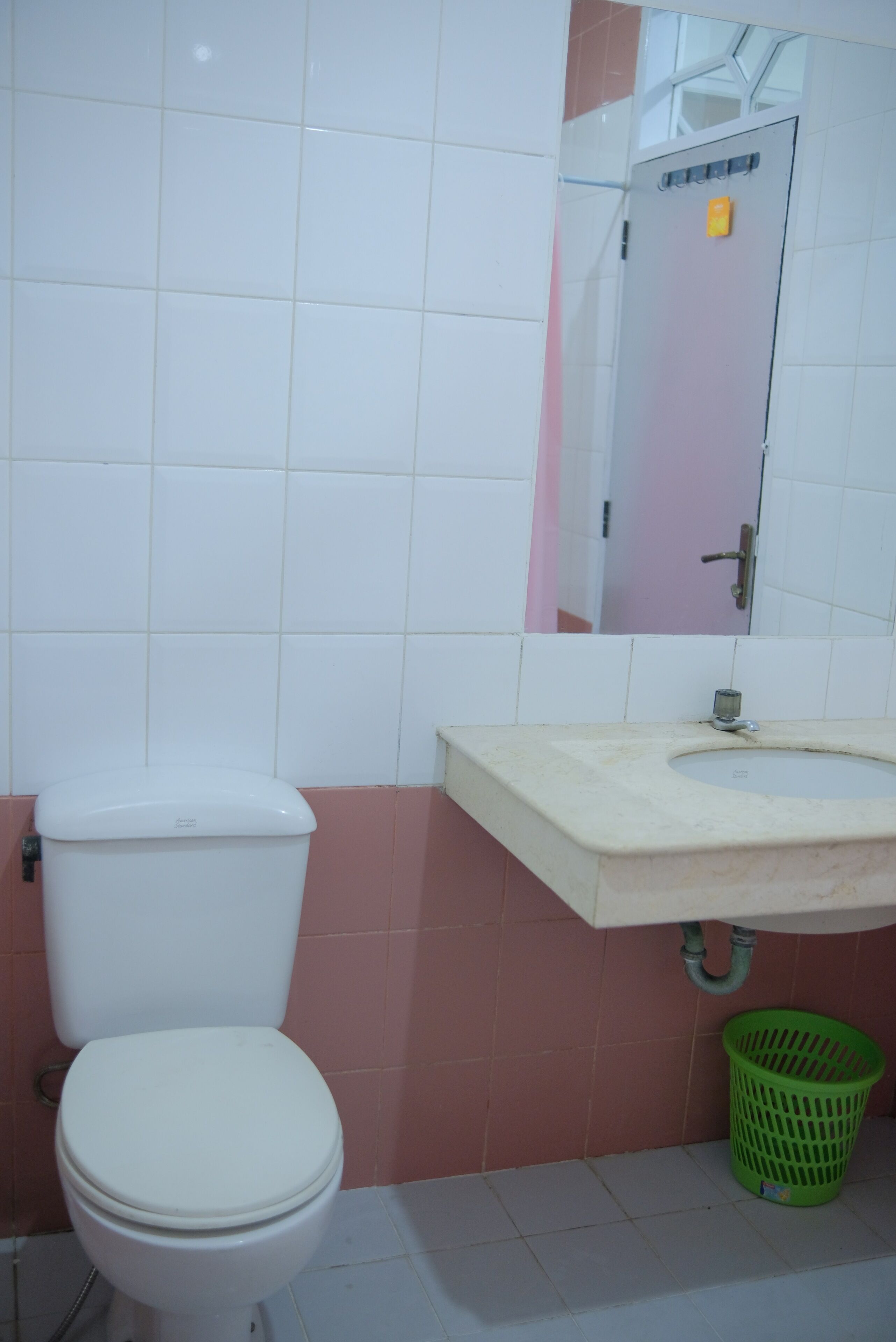Ein Badezimmer mit Toilette, Waschbecken und Spiegel.