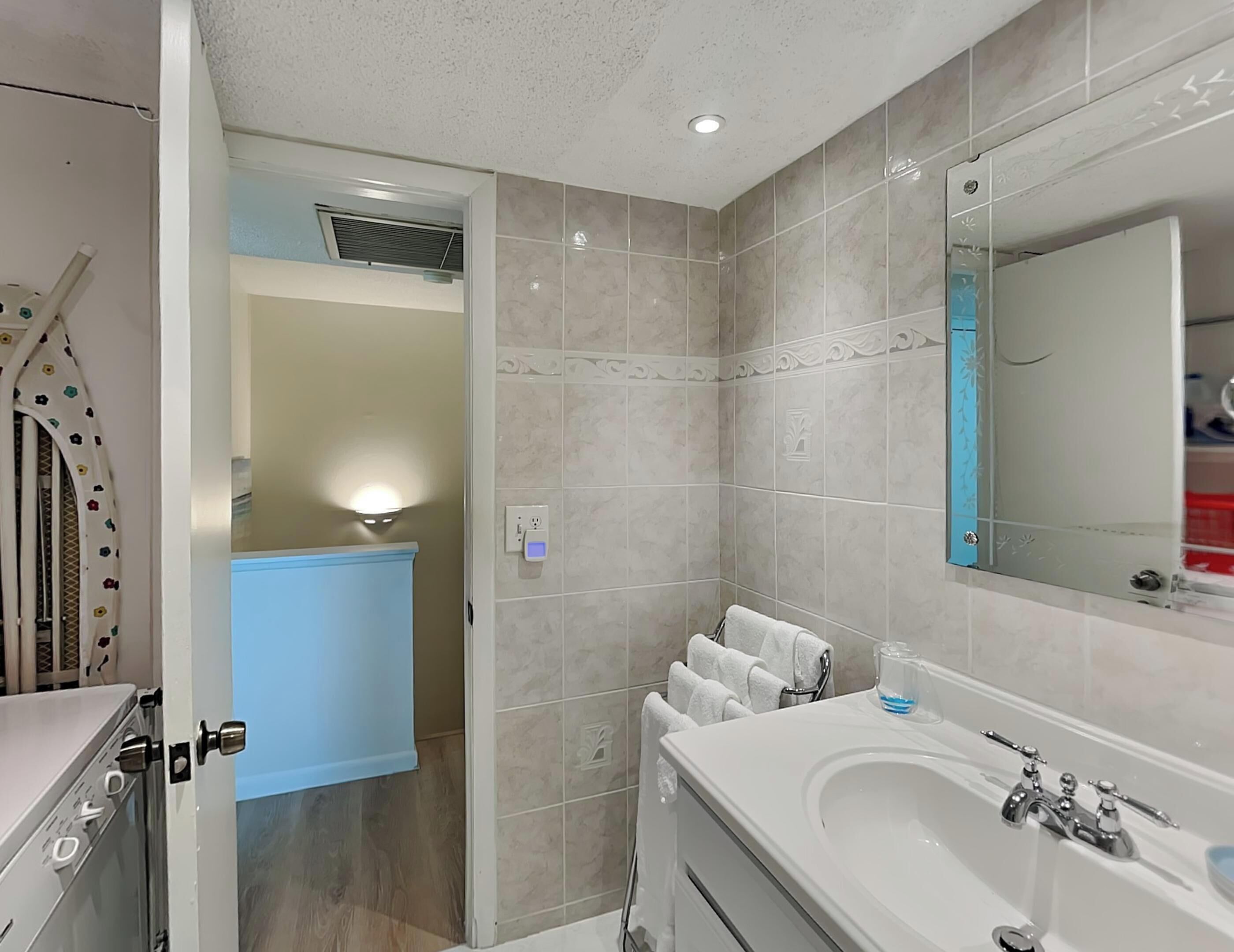A modern bathroom with a large mirror, a bathtub, and a shower area.