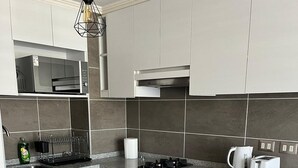 A modern kitchen with a granite countertop, stainless steel appliances, and a built-in oven. - Hermoso Apartamento  en Viña del Mar (Viña del Mar)