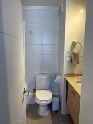 Une petite salle de bain comprenant des toilettes, un bidet et un petit lavabo.