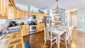 A kitchen with wooden cabinets, a dining table with chairs, and a chandelier.