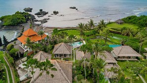 A resort with thatched-roof buildings, a swimming pool, and a view of the ocean. - Villa Tanju by Elite Havens (Cemagi)