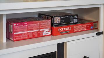 Un estante con dos cajas de Scrabble y una caja de mil piezas.