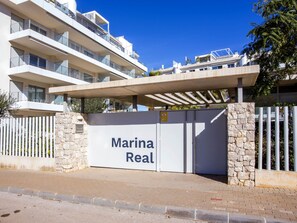A gated entrance to a modern residential building named "Marina Real" with a clear blue sky in the background. - Marina Real I by Interhome (Dénia)