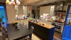 Una cocina moderna con una isla central, electrodomésticos integrados y un área de comedor con una mesa y sillas.