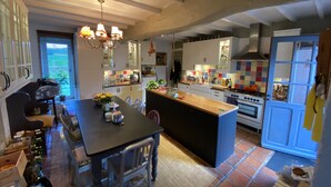 Una cocina moderna con una isla central, electrodomésticos integrados y una zona de comedor con mesa y sillas.