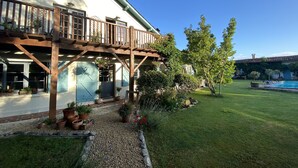 Una casa con terraza de madera y piscina.