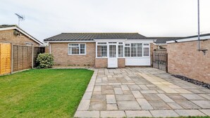 A residential property with a paved driveway, a small lawn, and a brick house with a tiled roof. - Marine Lodge -  a bungalow that sleeps 4 guests  in 2 bedrooms (Bognor Regis)