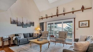 Una sala de estar con sofá, sillones, una mesa de centro y chimenea.