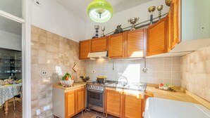 Una cocina con armarios de madera, un horno de acero inoxidable y un lavabo.