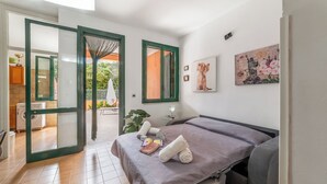Un dormitorio con cama, ventana, un cuadro y vistas al exterior.