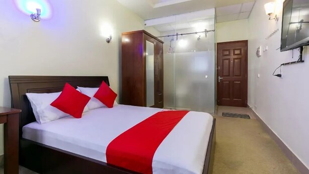 A hotel room with a bed, a wardrobe, a mirror, a television, and a door. - Minh Phương HBC Hotel - by Bay Luxury (Ho Chi Minh City)