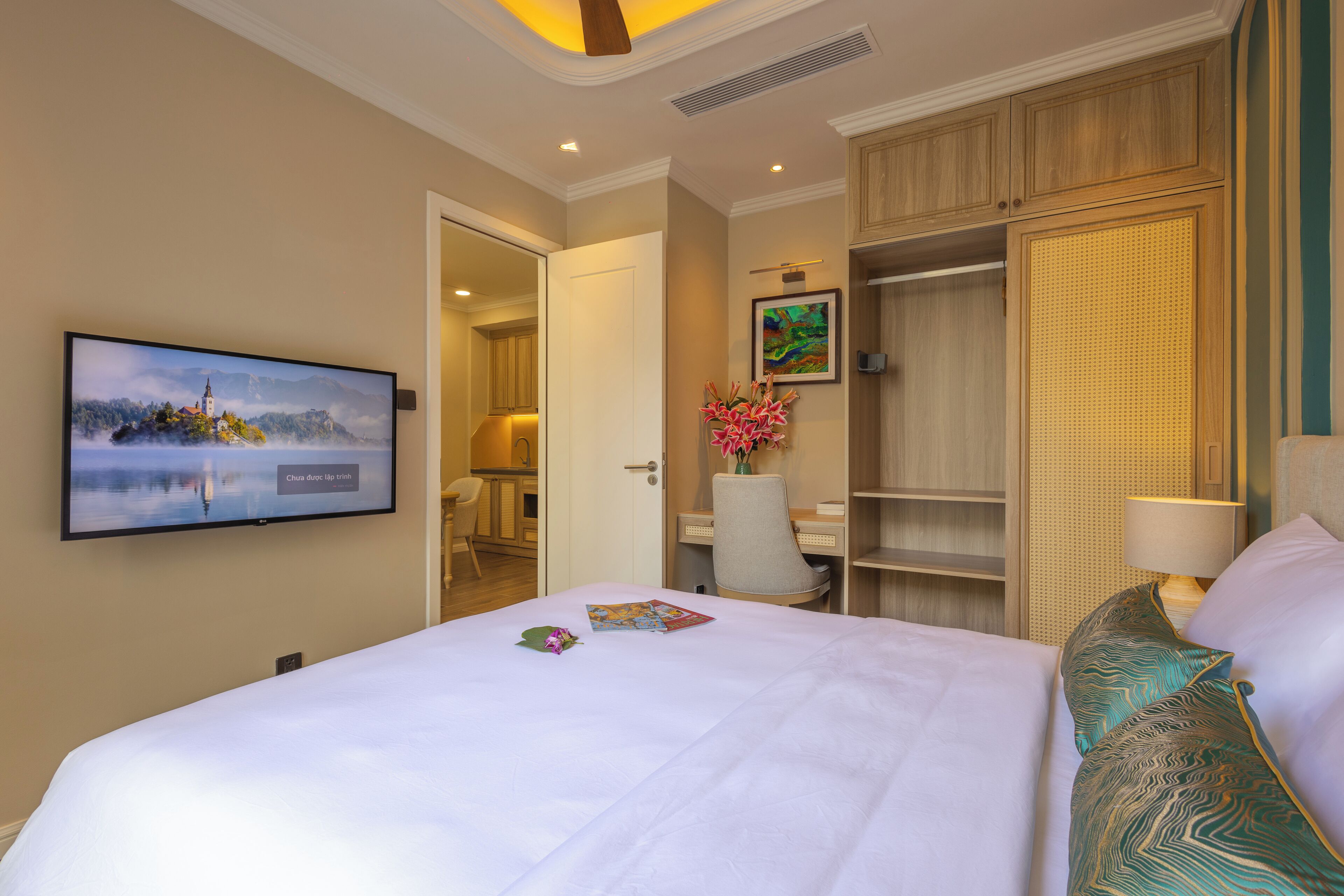 Une chambre d’hôtel avec un grand lit, un bureau, une chaise, une télévision et une armoire.