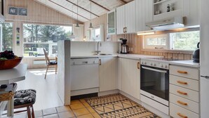 A modern kitchen with white cabinets, a built-in oven, and a coffee maker. - "Akka" - 2km from the sea by Interhome (Saltum)