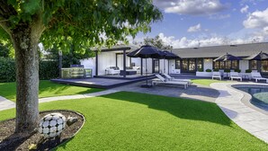 A modern outdoor area with a pool, lounge chairs, and a covered seating area. - Modern Ranch House-swim, soak, pickleball & walk to wineries (Sonoma)