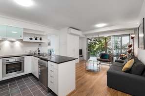 A modern kitchen with white cabinetry, a built-in oven, and a dishwasher.