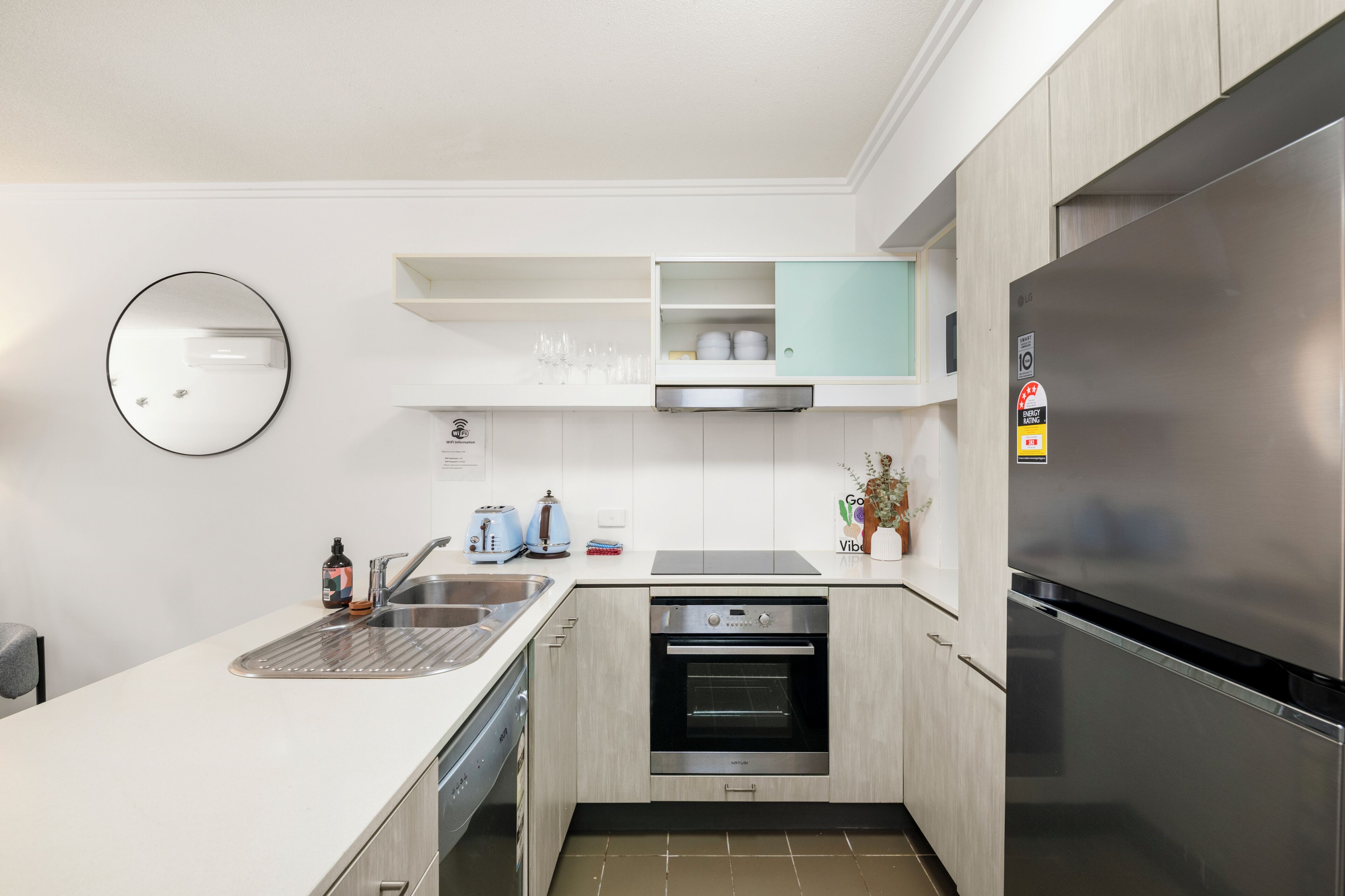 Una cocina moderna con refrigerador de acero inoxidable, horno empotrado y lavavajillas.