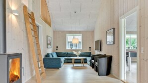 A cozy living room with a fireplace, a sofa, a coffee table, and a TV.