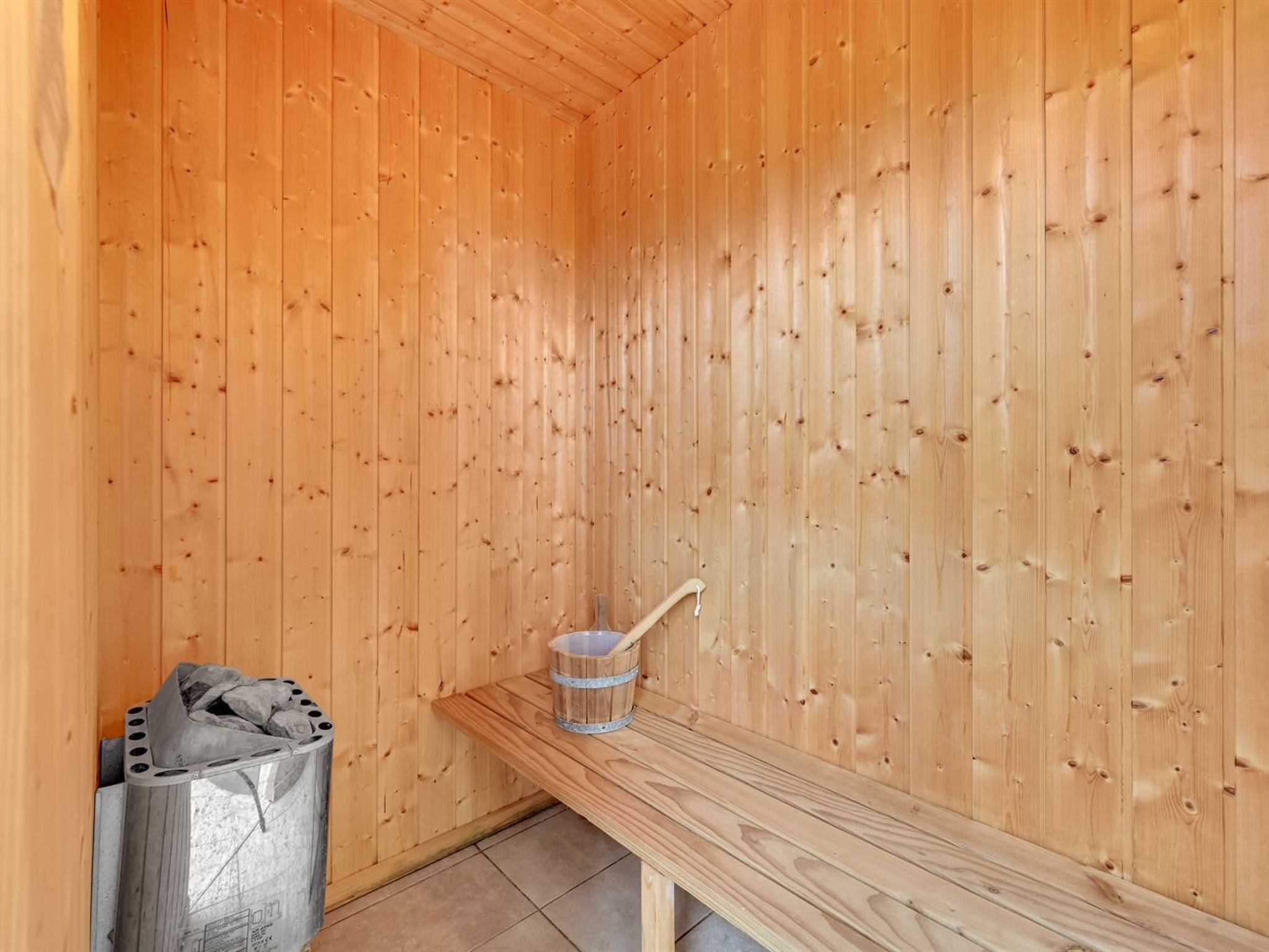 Una sauna amb parets de fusta i una banca.