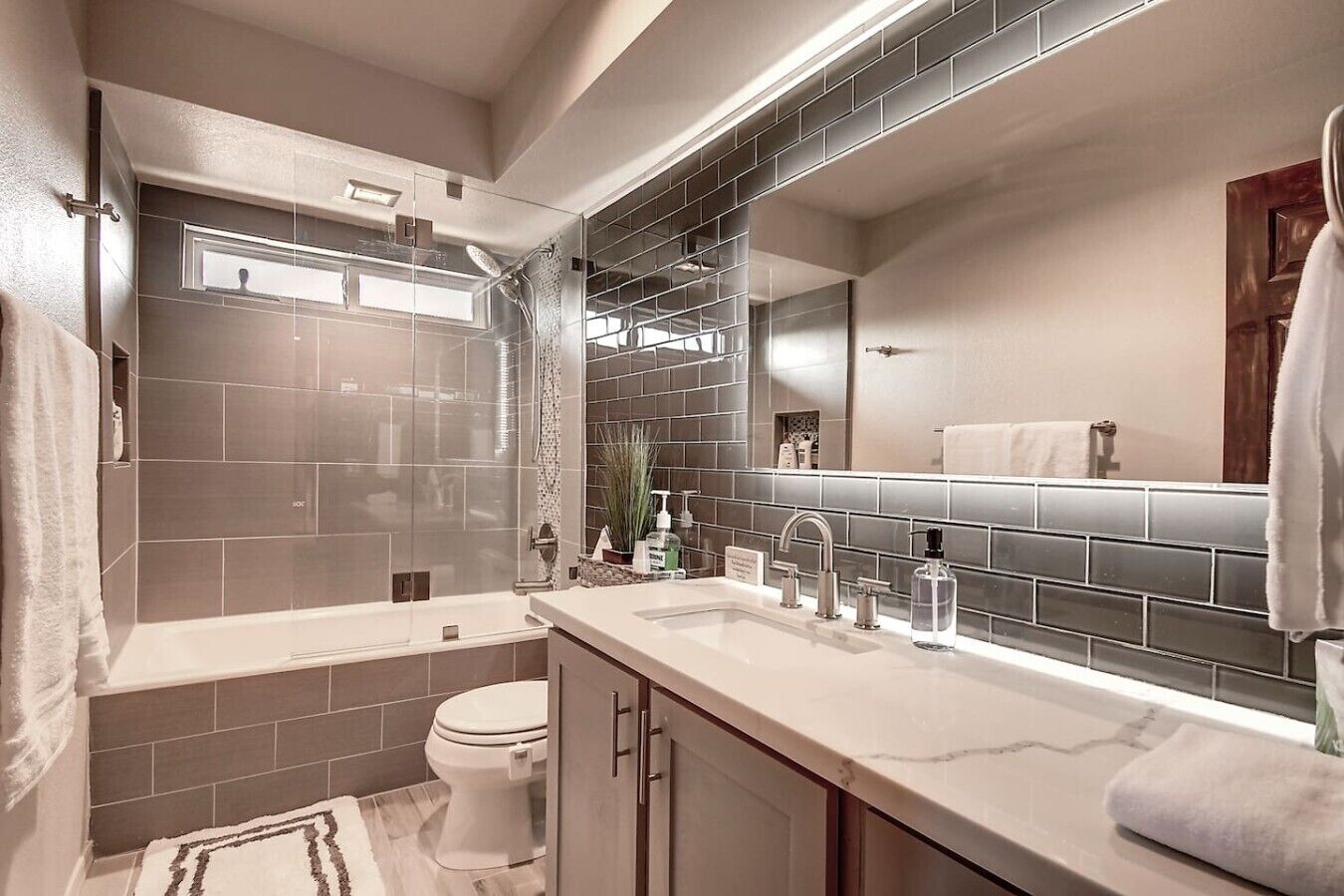 A modern bathroom with a bathtub, toilet, and sink.