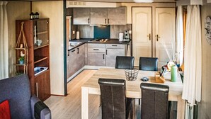 A compact living space with a dining area, kitchenette, and a sofa. - Nice (sta)caravan in Reutum with WiFi (Reutum)