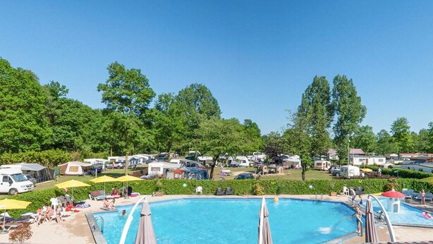 A large outdoor swimming pool surrounded by camping trailers and trees. - Nice (sta)caravan in Reutum with WiFi (Reutum)