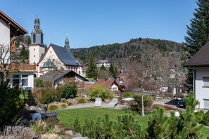 A residential area with a church, houses, and a hill in the background.