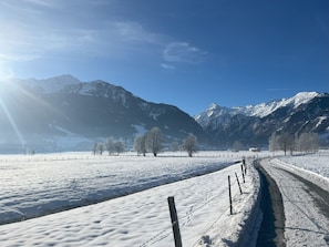 A snow-covered landscape with mountains in the background and a clear sky.