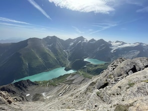 A mountainous landscape with a turquoise lake, rocky terrain, and distant peaks.