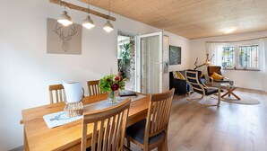 A dining area with a wooden table, chairs, and hanging pendant lights.