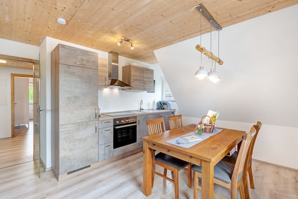 Une cuisine moderne avec des meubles de rangement en bois, une table à manger et des chaises.