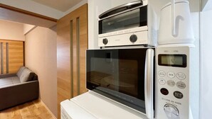 Une cuisine compacte équipée d’un four à micro-ondes, d’un four et d’une machine à café.