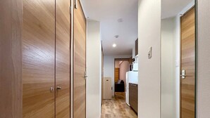 Un couloir avec des portes en bois et, au fond, un espace cuisine.