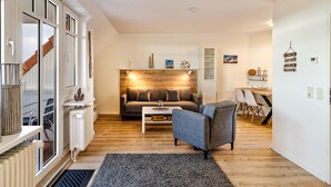 Ein modernes Wohnzimmer mit einer Couch, einem Couchtisch und einem Essbereich mit Stühlen.