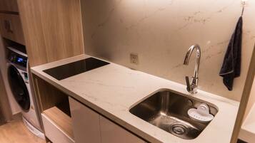 A modern kitchen with a built-in sink, a dishwasher, and a washing machine.