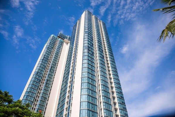 A tall, modern skyscraper with a curved facade and numerous windows. - Blue Kites Apartment (Bai Chay)