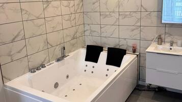 Vasca idromassaggio, asciugamani, carta igienica