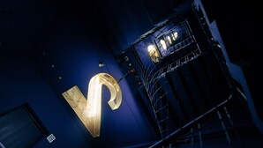 A large illuminated letter 'P' on a building facade at night. - The Blue By Just Inn (Taipei)