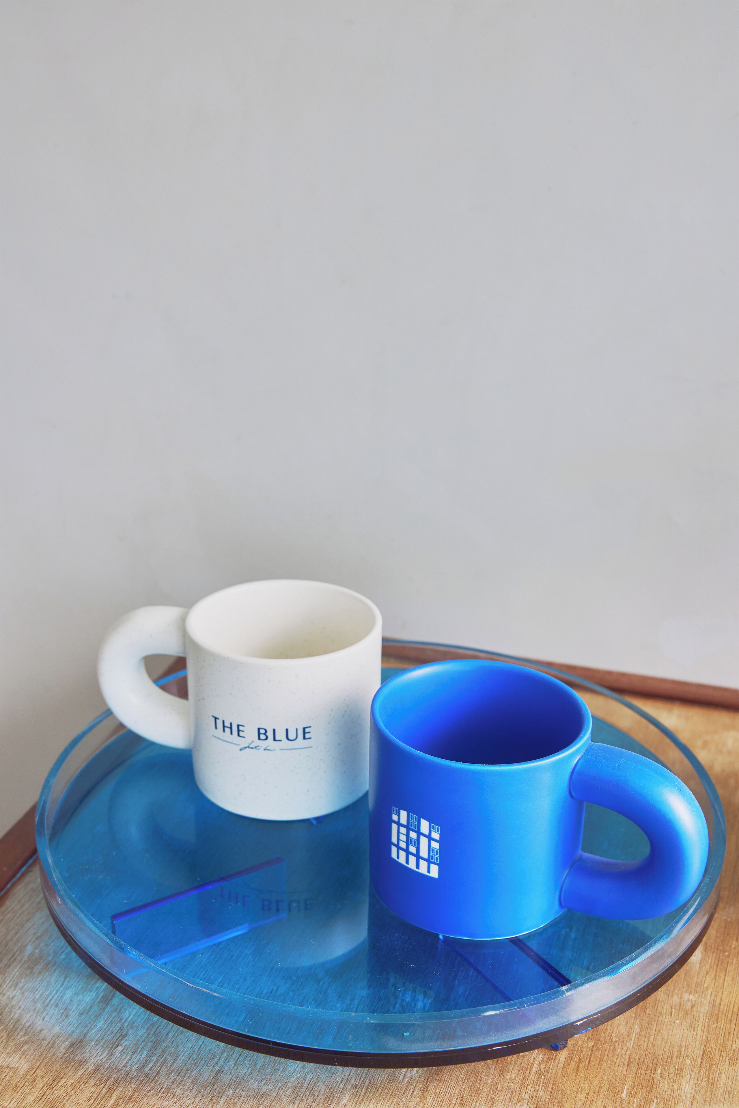Two mugs on a glass tray.
