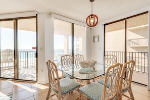 Enjoy a casual dining or lounging space with access to the beach from this room's expansive balcony.