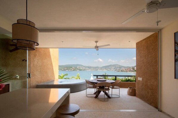 A modern kitchen with a view of a body of water and mountains.