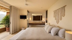 Quarto de hotel com cama grande, banheiro com espelho e vista para o exterior.