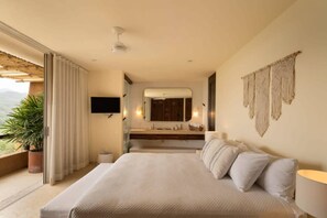 A hotel room with a large bed, a bathroom with a mirror, and a view of the outdoors. - Luxury Penthouse | Private Pool Steps from La Ropa (Zihuatanejo)