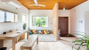 A modern room with a wooden ceiling, a large window, a wooden bench, and a door. - Spaciouse Private Hot Spring, Spotless 3 BDR with Stylish Modern Japanese Deco (Ito)